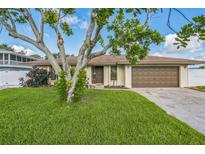 Charming home featuring a well-manicured lawn, mature trees, and a two-car garage at 2204 78Th W St, Bradenton, FL 34209