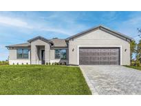 Charming single-story home featuring a gray exterior, manicured lawn, and a two-car garage with a paved driveway at 2330 Hiers Rd, Dover, FL 33527