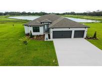 Charming single-story home with a three-car garage, and a well-manicured lawn with lake view at 2414 Hiers Rd, Dover, FL 33527