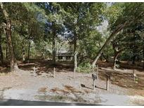 A home exterior behind a sparse fence shaded by mature trees at 25425 Olympia Rd, Brooksville, FL 34601
