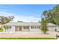 Charming single-story home featuring a brick facade, a spacious driveway, and manicured landscaping at 2554 Lake Ellen Cir, Tampa, FL 33618