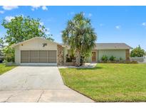 Charming single-story home featuring a well-maintained lawn, stone accents, and mature palm tree at 3226 Gardenia Dr, Hernando Beach, FL 34607