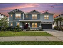 Charming two-story home featuring a well-manicured lawn, covered entry, and attached garage with an ample driveway at 33774 Castaway Loop, Wesley Chapel, FL 33543