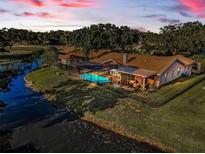 Aerial view of a screened pool in backyard surrounded by a dark metal fence at 395 Forest Park Rd, Oldsmar, FL 34677