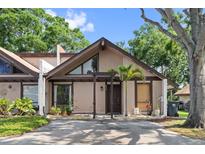 Charming home featuring a unique architectural design and a well-maintained front yard with mature trees at 4013 Muriel Pl, Tampa, FL 33614