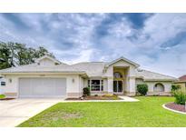 Charming single-story home featuring a well-manicured lawn, arched entryway, and a two-car garage at 4368 Las Palmas Ave, Spring Hill, FL 34606