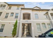 A three-story condo building showing front entrance with covered access and stairs to upper floors at 5052 Sunridge Palms Dr # 102, Tampa, FL 33617