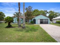 Charming single-story home with a well-manicured lawn and a brick-paved driveway at 8332 Berkeley Manor Blvd, Spring Hill, FL 34606