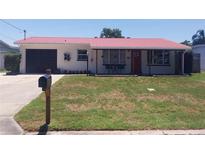 Charming home featuring a well-maintained front yard and a distinctive red metal roof at 10142 118Th Ave, Largo, FL 33773