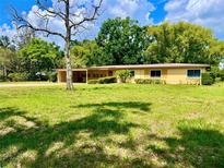 Charming single-story home features a well-manicured front yard with mature landscaping and a covered front porch at 10308 Fore Dr, Tampa, FL 33612