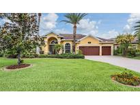Lovely yellow home with a 3-car garage and beautiful landscaping at 10641 Cory Lake Dr, Tampa, FL 33647
