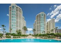 Stunning view of high-rise buildings from the pool with palm trees, perfect for relaxation and luxury living at 1180 Gulf Blvd # 306, Clearwater, FL 33767