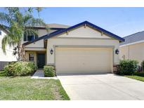 Charming two-story home featuring a manicured lawn, two-car garage, and welcoming curb appeal at 1210 Harbour Blue St, Ruskin, FL 33570