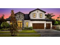 Beautiful two-story home featuring mixed stone and stucco, a three-car garage, and landscaped front yard at 125 Hidden Estates Ct, Brandon, FL 33511