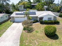 Charming single-story home with well-kept lawn, front yard foliage, solar panels, and spacious two-car garage at 1598 Brookside Blvd, Largo, FL 33770