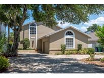 Charming two-story home featuring an attached garage, well-maintained landscaping, and arched windows at 2120 S Hesperides St, Tampa, FL 33629