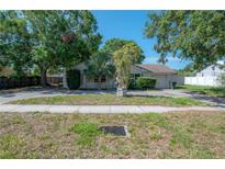 Cozy single-story home featuring mature trees, a large front yard, and a convenient circular driveway at 3256 Adrian Ave, Largo, FL 33774
