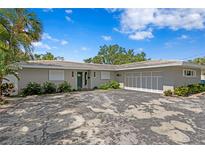 Charming single-story home with a well-maintained front yard, lush greenery, and an attached two-car garage at 4649 Neptune Se Dr, St Petersburg, FL 33705