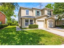 Charming two-story townhome with manicured lawn, two-car garage, and inviting curb appeal at 2032 Sunset Meadow Dr, Clearwater, FL 33763