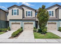 Charming townhome with individual garages, manicured landscaping, and neutral color palette at 5024 Sylvester Loop, Tampa, FL 33610