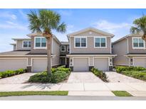 Charming townhomes with a brick-paved drive, garages, and well manicured tropical landscaping at 5496 Riverwalk Preserve Dr, New Port Richey, FL 34653