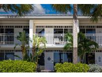 Charming two-story condo building with white trim, balconies, tropical foliage and a serene, inviting atmosphere at 611 Destiny Dr # 204, Ruskin, FL 33570