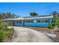 Bright blue single-story home with green shutters and solar panels on a sunny day at 6132 7Th S Ave, Gulfport, FL 33707