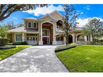 Stately home with a grand entrance, manicured lawn, and circular driveway at 704 Berrocales De Avila, Tampa, FL 33613