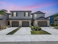 New construction townhomes featuring multi-car garages, modern exteriors, and manicured landscaping at 841 Royal Empress Dr, Ruskin, FL 33570