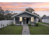 Charming single-story home with a cozy front porch and well-maintained lawn at sunset at 1206 E Frierson Ave # B, Tampa, FL 33603