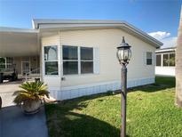 Charming manufactured home featuring vinyl siding, manicured lawn and mature landscaping for a serene curb appeal at 1710 7Th Sw St # 85, Ruskin, FL 33570