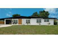 Charming single-story home with a modern black roof, white facade, and minimalist landscaping at 323 48Th Nw St, Bradenton, FL 34209