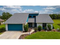 Charming single-Gathering home with well-maintained lawn, attached garage, and vibrant turquoise accents at 34507 Cedarfield Dr, Dade City, FL 33523