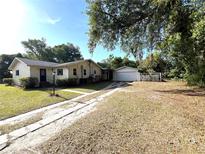 Charming single-story home featuring a detached garage and a long driveway at 403 E Carolina Ave, Plant City, FL 33563