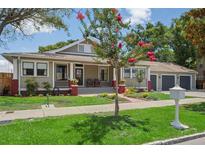 Charming home with a well-manicured lawn, brick accents, and a covered front porch with rocking chairs at 4913 N Central Ave, Tampa, FL 33603