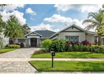 Charming home showcasing a landscaped front yard, lush greenery, and a paved driveway leading to a welcoming entrance at 5314 Alafia Falls Dr, Lithia, FL 33547