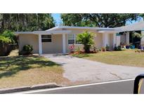 Charming single-story home featuring a well-maintained front yard with colorful landscaping and a long driveway at 6434 Old Main St, New Port Richey, FL 34653