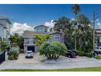Charming multi-story home with mature trees, a driveway, and an attached garage at 803 Harbor Dr, Belleair Beach, FL 33786