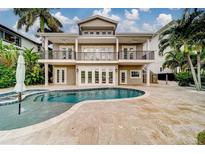 Backyard view of a luxurious home showcasing a private pool and patio at 803 Harbor Dr, Belleair Beach, FL 33786