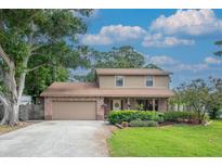 Charming two-story home featuring a brick facade, well-manicured lawn, and a welcoming two-car garage at 9465 126Th Ave, Largo, FL 33773