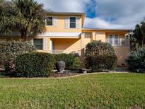 A charming, two-story home boasts a well-manicured lawn and lush landscaping, adding to its curb appeal at 101 8Th St, Belleair Beach, FL 33786