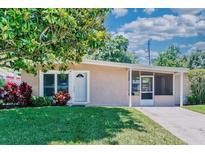Charming single story home featuring a well manicured lawn, mature trees and a welcoming front porch at 10410 Ventura Ave, Tampa, FL 33619