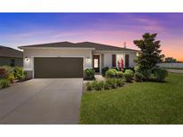 Charming single-story home with manicured lawn, beautiful landscaping, and a two-car garage at 12697 Achasta Blvd, Hudson, FL 34669