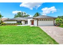 Charming single-story home with a lush green lawn and a brick driveway leading to a two-car garage at 15108 Springview St, Tampa, FL 33624