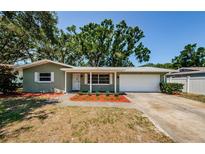 Charming home featuring a well-maintained front yard and a convenient attached garage at 1926 Fairway W Cir, Dunedin, FL 34698