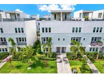 Beautiful modern townhomes feature lush landscaping, private balconies, and a charming brick pathway at 2442 W Mississippi Ave # 5, Tampa, FL 33629