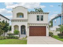 Charming two-story stucco home featuring a two-car garage and beautifully landscaped front yard at 4115 N Blvd, Tampa, FL 33603