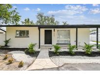 Charming single-story home with white exterior, black trim, and rock landscaping at 4461 Shore Acres Ne Blvd, St Petersburg, FL 33703