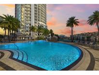 Luxurious community pool with waterfall feature, surrounded by palm trees and lounge chairs, offering a resort-style experience at 449 S 12Th St # 1201, Tampa, FL 33602