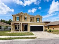Charming two-story home featuring a covered entryway, two-car garage, and well-maintained lawn at 4916 Rolling Green Dr, Wesley Chapel, FL 33543